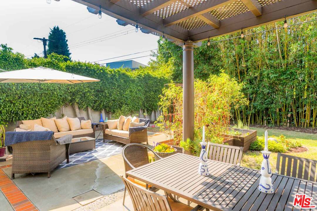 7418 Midfield Avenue Los Angeles, CA 90045 - Photo 19 of 28 a view of a patio with couches table and chairs under an umbrella with a large tree