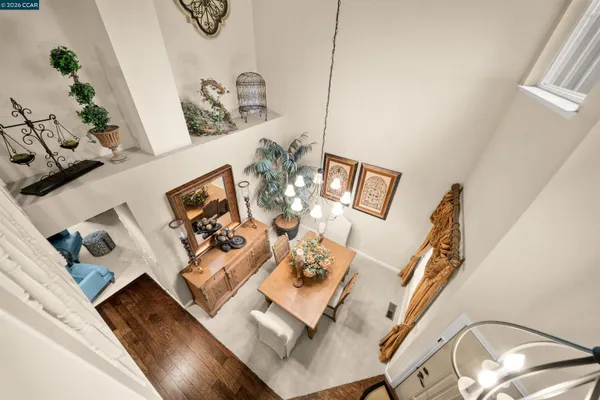 a living room with couches and a dining table with wooden floor