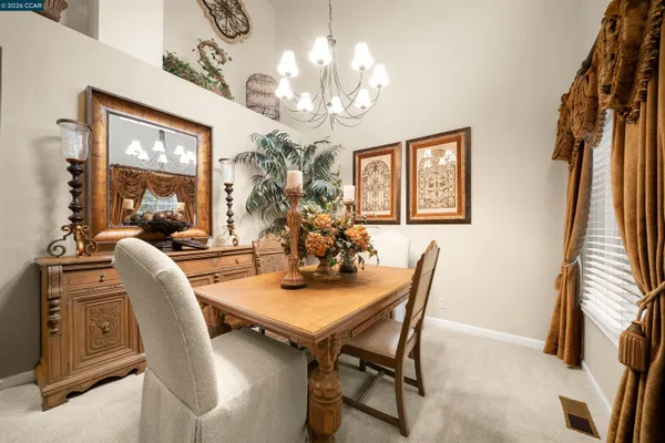 a view of a dining room with furniture and a chandelier