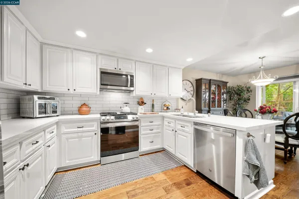 a kitchen with white cabinets and stainless steel appliances