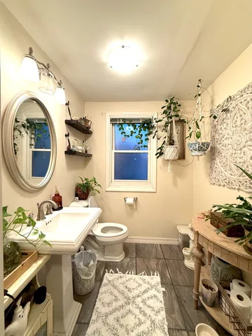 a bathroom with a toilet sink and mirror