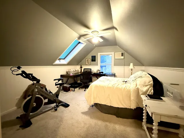 a bedroom with bed and a chandelier