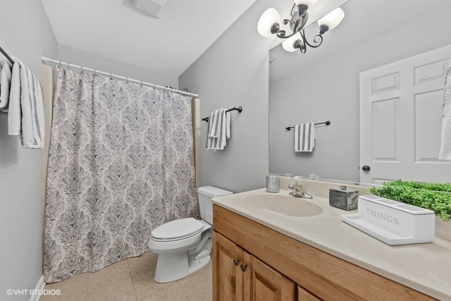 411 South Wilke Road Arlington Heights, IL 60005 - Photo 17 of 29 a bathroom with a granite countertop sink a toilet and a mirror
