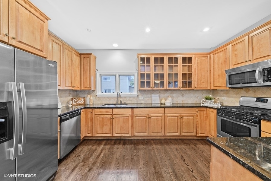 411 South Wilke Road Arlington Heights, IL 60005 - Photo 4 of 29 a kitchen with granite countertop stainless steel appliances and wooden cabinets