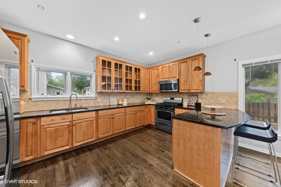 411 South Wilke Road Arlington Heights, IL 60005 - Photo 5 of 29 a kitchen with stainless steel appliances granite countertop wooden cabinets a sink dishwasher a stove and a refrigerator with wooden floor