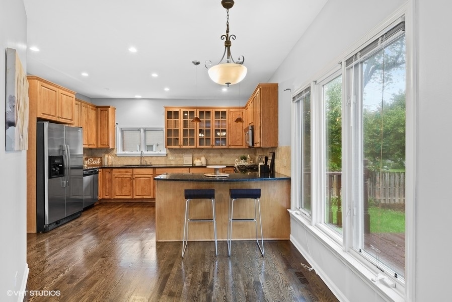 411 South Wilke Road Arlington Heights, IL 60005 - Photo 6 of 29 a kitchen with stainless steel appliances granite countertop a refrigerator a sink dishwasher a stove and white countertops with wooden floor