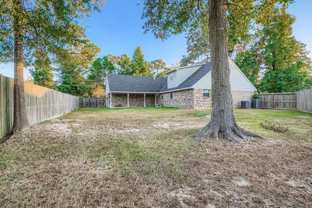 a view of a house with backyard and a tree