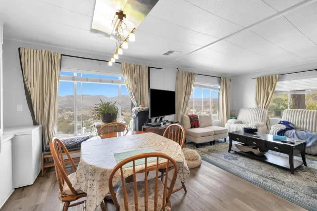 a living room with furniture a flat screen tv and a large window