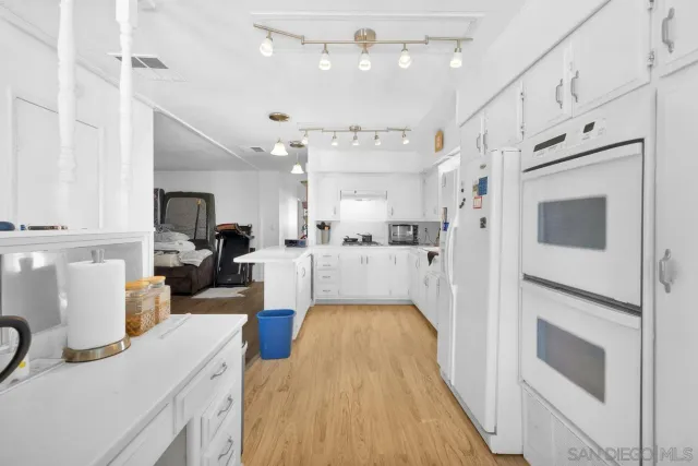 a kitchen with stainless steel appliances granite countertop a refrigerator and a stove