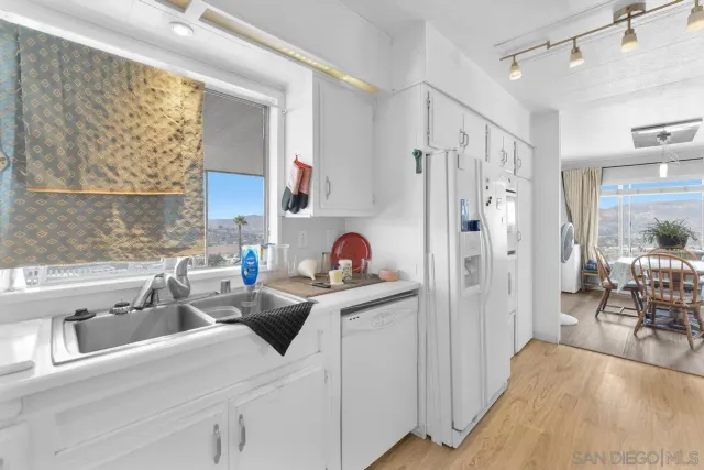 a kitchen with stainless steel appliances granite countertop a sink and a refrigerator