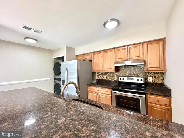 a kitchen with a stove top oven and refrigerator