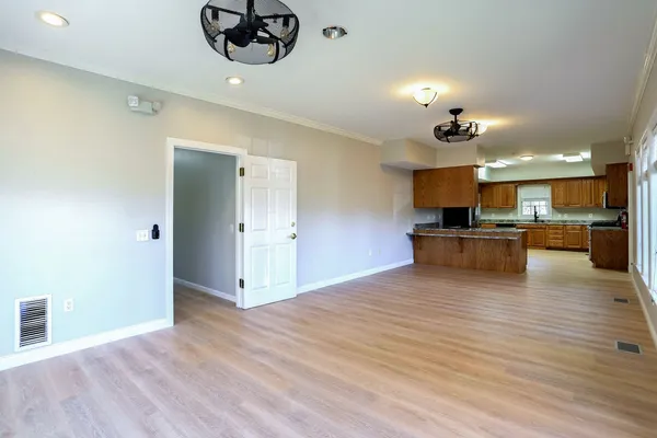 a kitchen with stainless steel appliances granite countertop wooden cabinets a stove top oven a sink and dishwasher with wooden floor