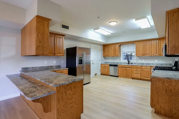 a kitchen with stainless steel appliances granite countertop a refrigerator and a stove