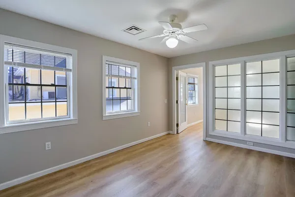 a view of an empty room with wooden floor