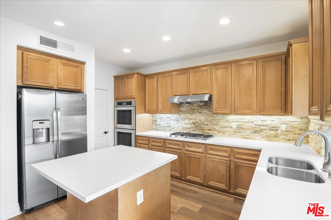 5 Sachem Way Ladera Ranch, CA 92694 - Photo 21 of 37 a kitchen with kitchen island granite countertop a sink a counter top stainless steel appliances and cabinets