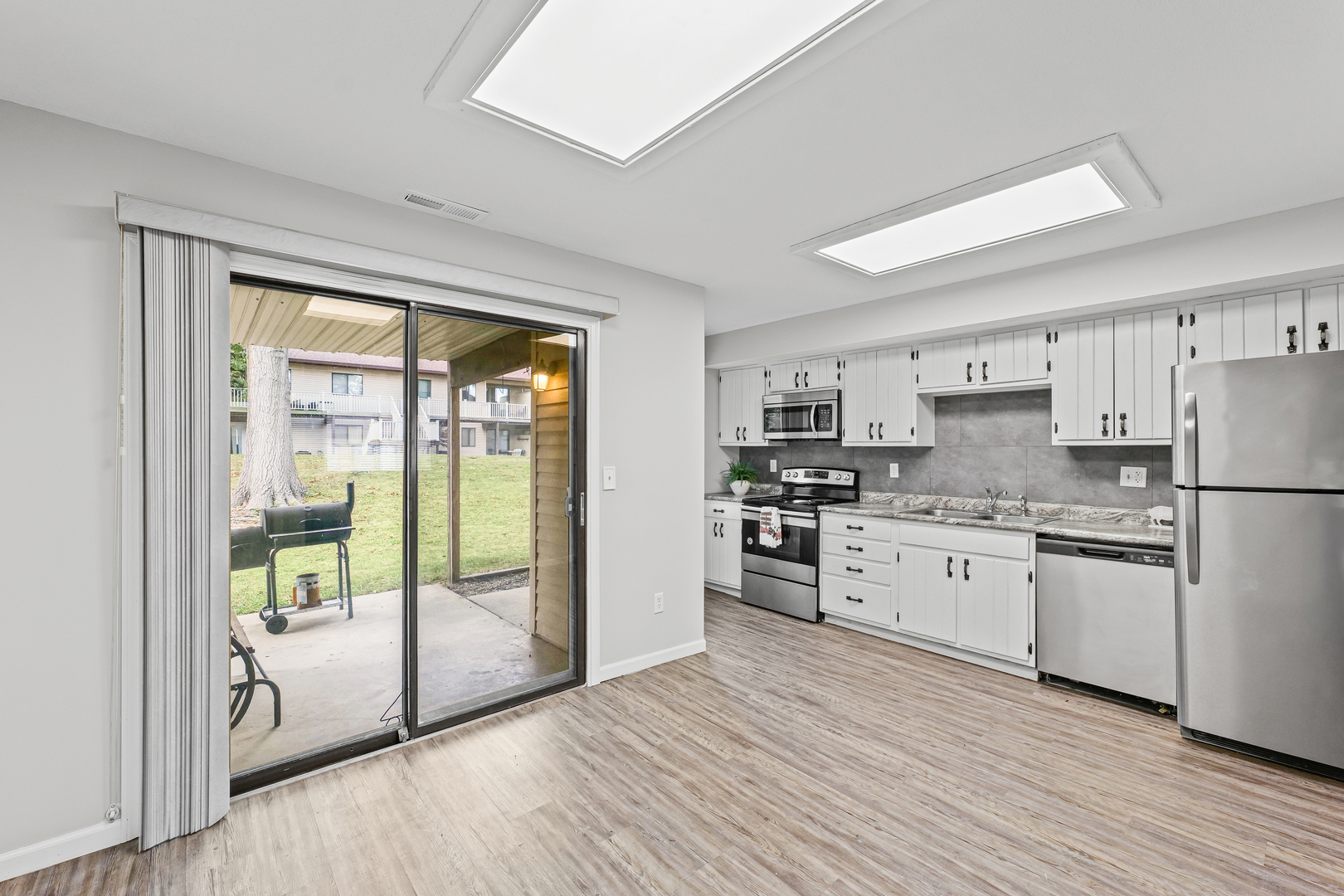 1302 Christopher Circle, Unit 4 Urbana, IL 61802 - Photo 3 of 17 a kitchen with stainless steel appliances granite countertop a refrigerator a stove a sink and a large window