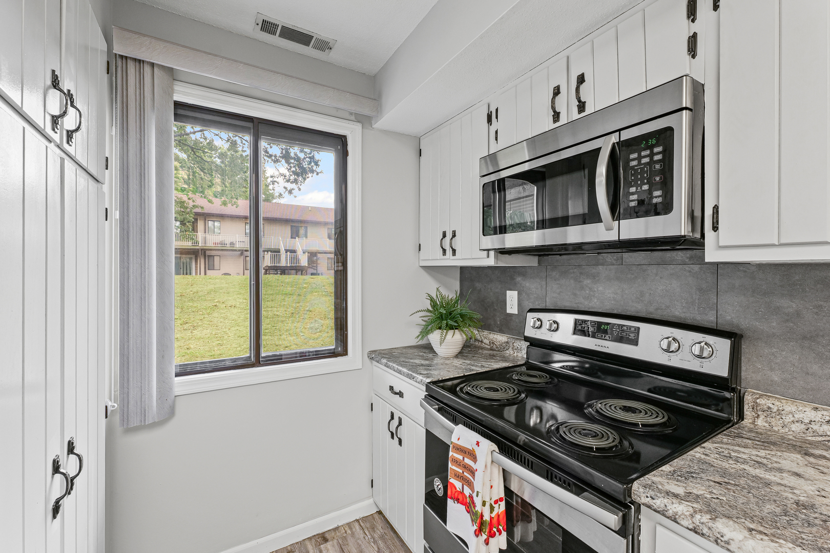 1302 Christopher Circle, Unit 4 Urbana, IL 61802 - Photo 4 of 17 a kitchen with stainless steel appliances granite countertop white cabinets and a stove top oven