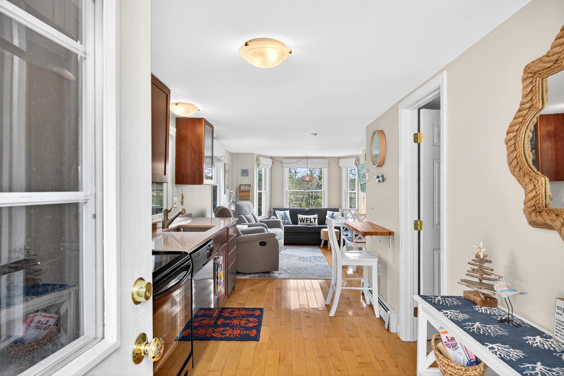 70 Commercial Street, Unit C Wellfleet, MA 02667 - Photo 9 of 32 a living room with furniture a rug and a chandelier