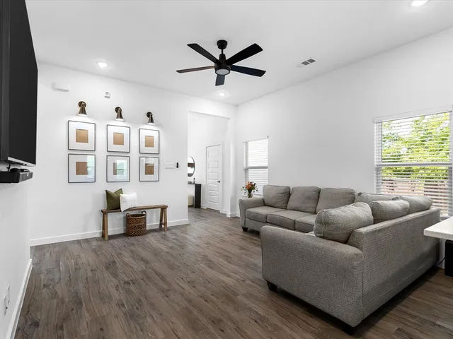 a view of kitchen with stainless steel appliances wooden floor and window