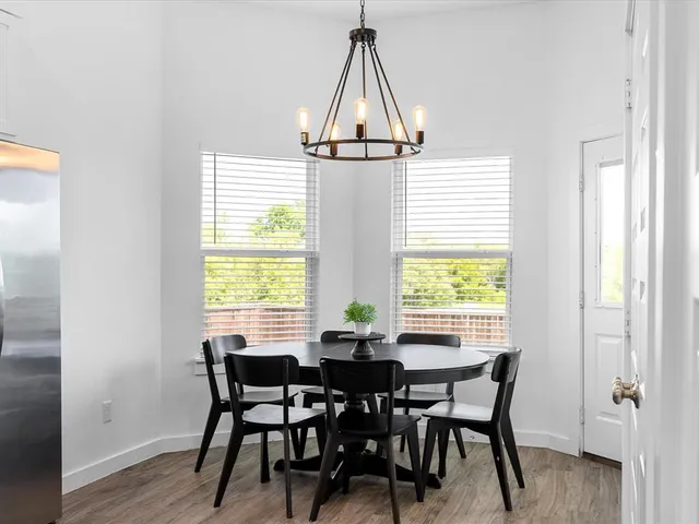 a kitchen with stainless steel appliances a white stove top oven a sink dishwasher and white cabinets with wooden floor