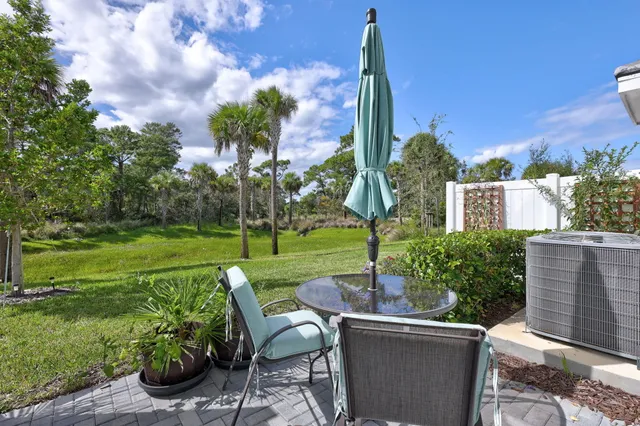 a view of a patio with table and chairs potted plants and palm tree