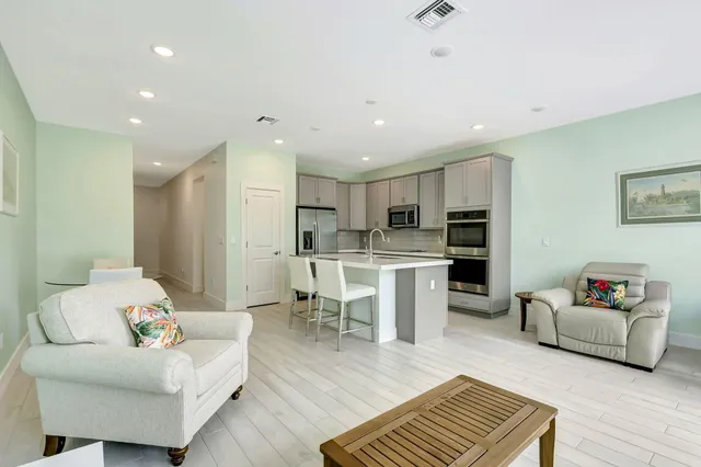 a living room with furniture and kitchen view