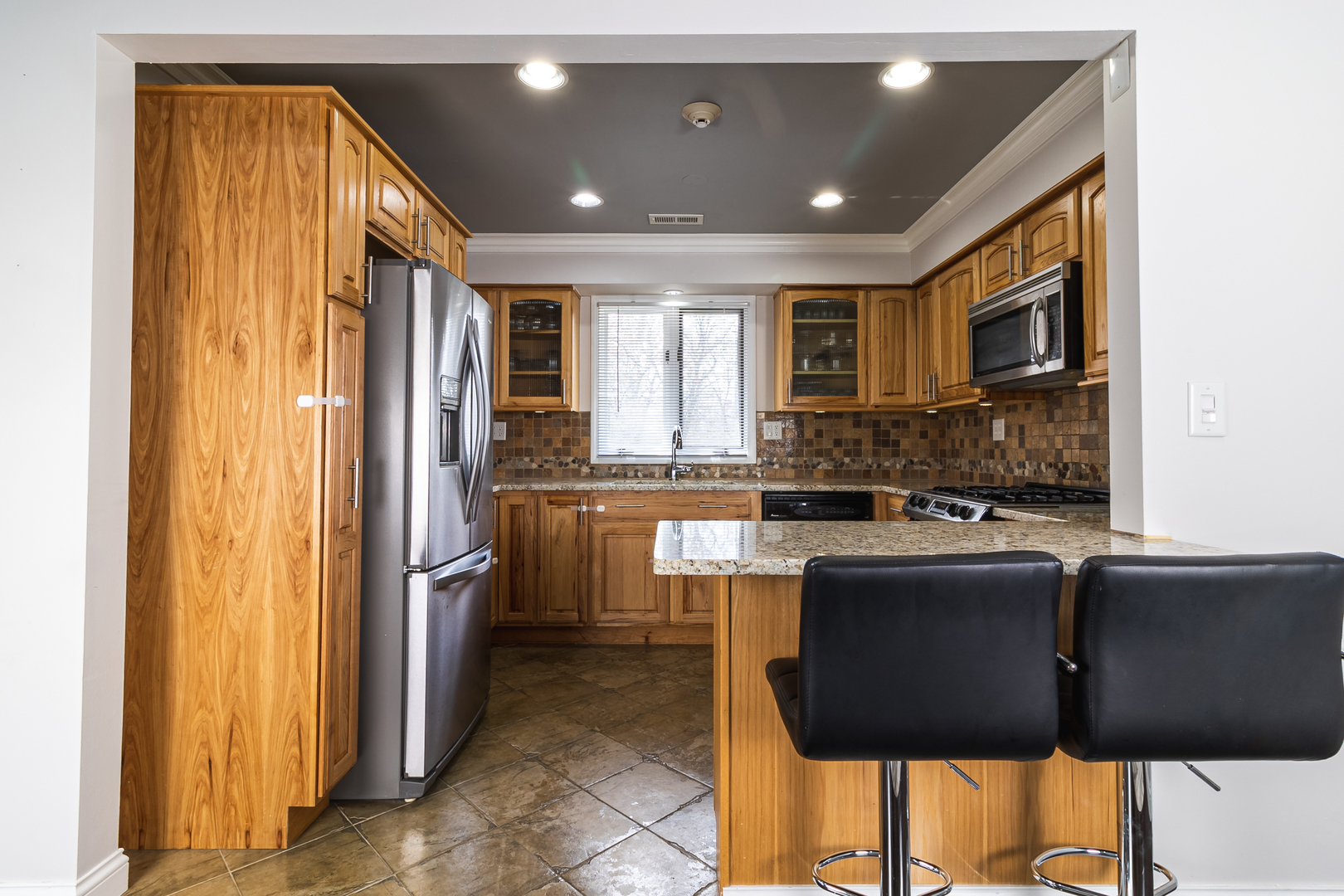 6317 Clarendon Hills Road, Unit 2 Willowbrook, IL 60527 - Photo 5 of 21 a kitchen with stainless steel appliances granite countertop a refrigerator a stove and a sink with wooden cabinets