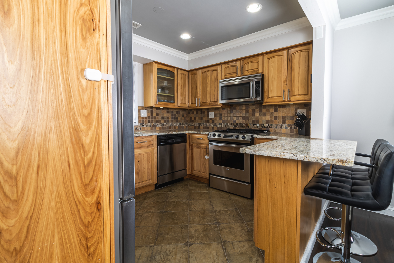 6317 Clarendon Hills Road, Unit 2 Willowbrook, IL 60527 - Photo 6 of 21 a kitchen with stainless steel appliances granite countertop a stove a sink dishwasher and a refrigerator
