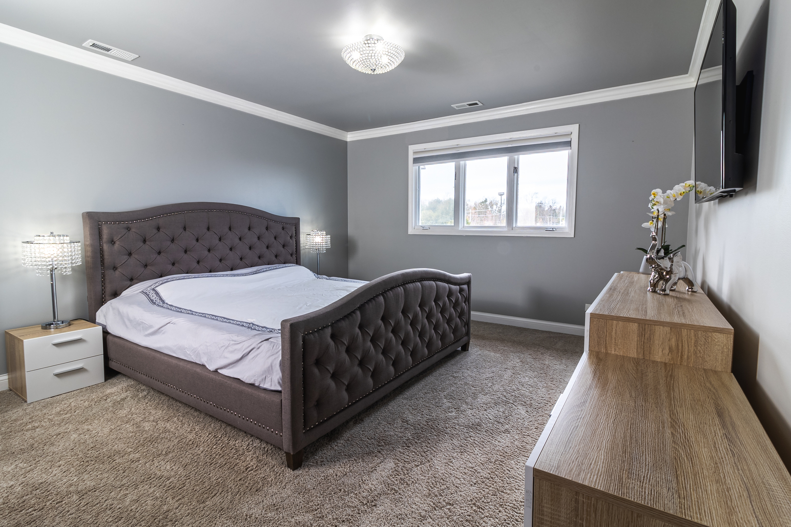 6317 Clarendon Hills Road, Unit 2 Willowbrook, IL 60527 - Photo 10 of 21 a bedroom with a bed and flat tv screen on the dresser