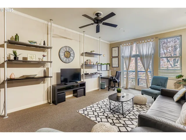 a living room with furniture a clock and a large window