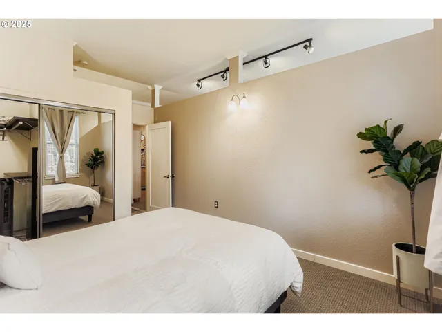 a bedroom with a bed and a potted plant