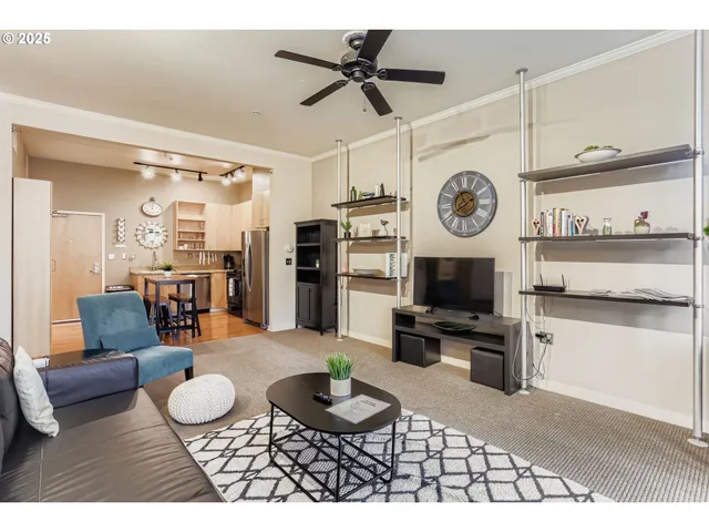 a living room with furniture a rug and kitchen view