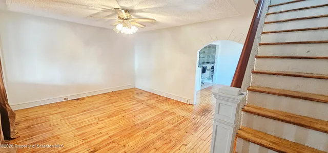 a view of a room with wooden floor and white walls