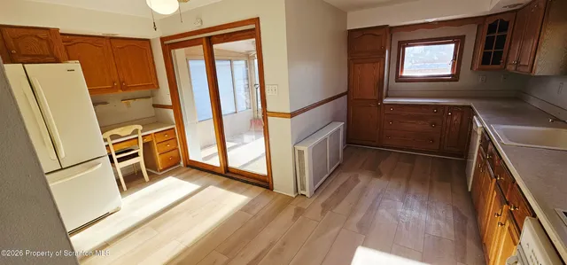 a view of a kitchen with wooden floor and electronic appliances