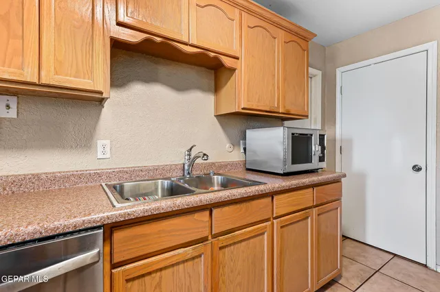 a kitchen with granite countertop a sink and cabinets