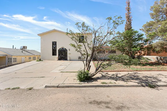 a view of a white house with a street