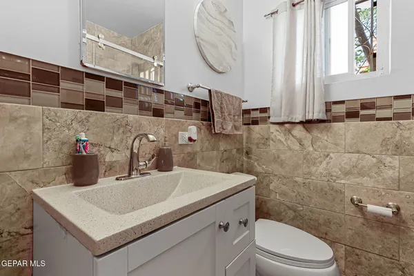 a bathroom with a sink a toilet and a mirror