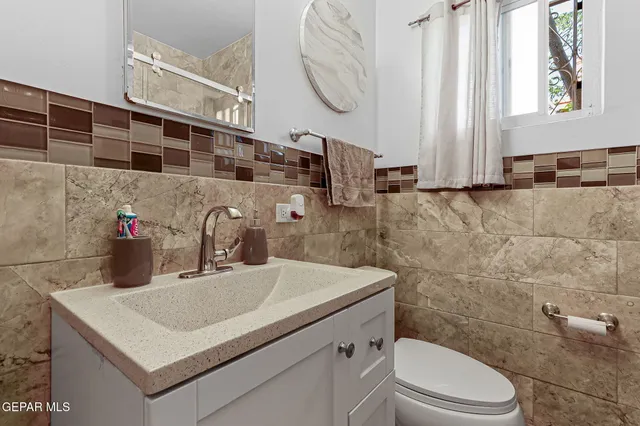 a bathroom with a sink a toilet and a mirror