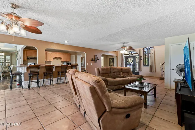 a living room with furniture a dining table and a chandelier