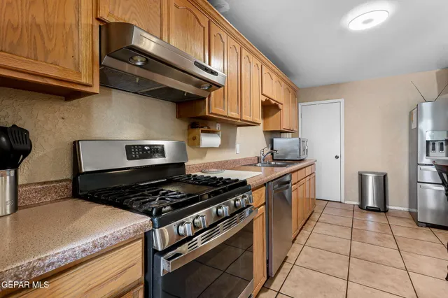 a kitchen with stainless steel appliances granite countertop a stove and a refrigerator