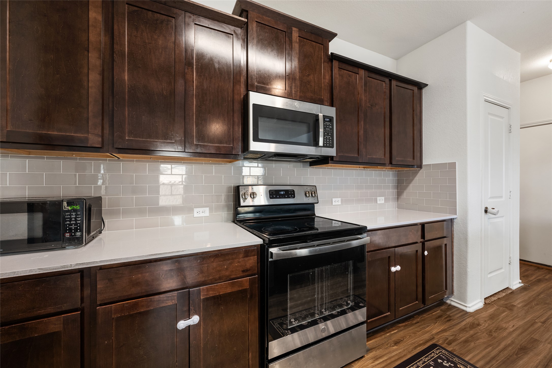 132 Joe Kidd Lane Jarrell, TX 76537 - Photo 9 of 39 a kitchen with granite countertop stainless steel appliances a stove microwave and sink