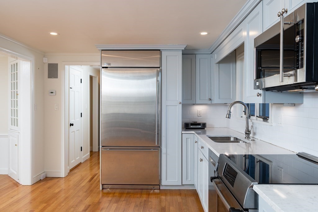4 King Philip Path Hingham, MA 02043 - Photo 3 of 21 a kitchen with a sink stainless steel appliances and cabinets