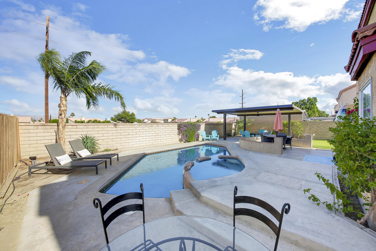 45640 Cimarron Road Indio, CA 92201 - Photo 21 of 25 a view of a swimming pool with a lounge chairs