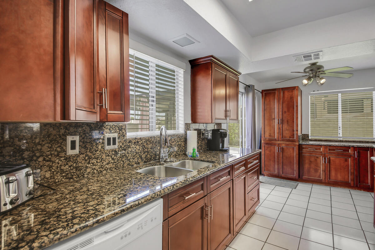 45640 Cimarron Road Indio, CA 92201 - Photo 10 of 25 a kitchen with stainless steel appliances granite countertop a sink counter space cabinets and a large window