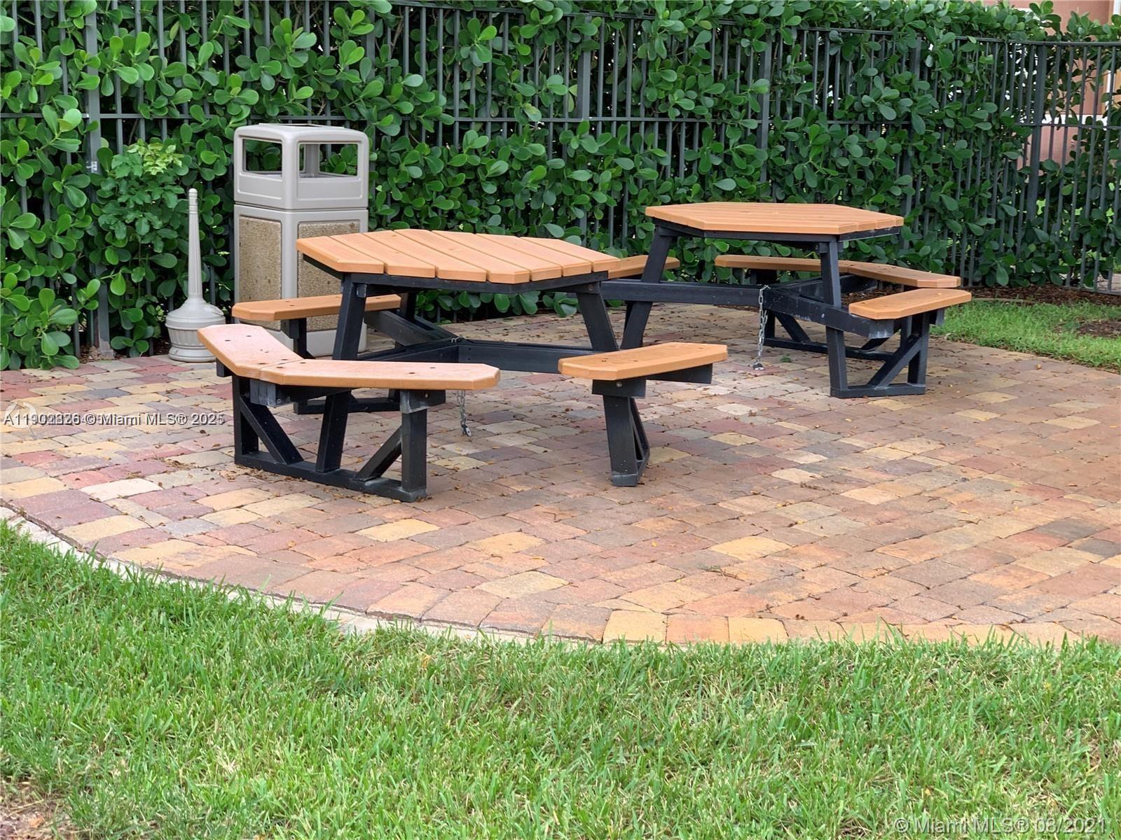 7816 Sonoma Springs Circle, Unit 104 Lake Worth, FL 33463 - Photo 9 of 12 an outdoor space with furniture and umbrella