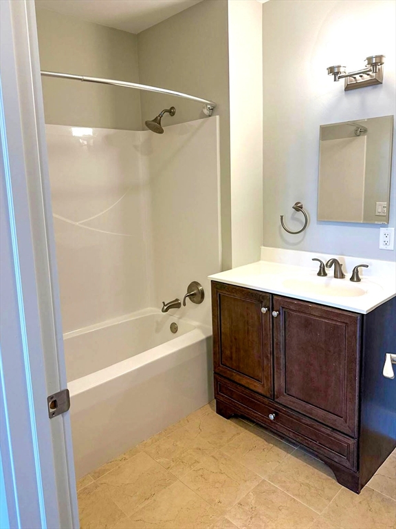 978 Worcester Street, Unit 310 Wellesley, MA 02482 - Photo 5 of 8 a bathroom with a tub sink and mirror