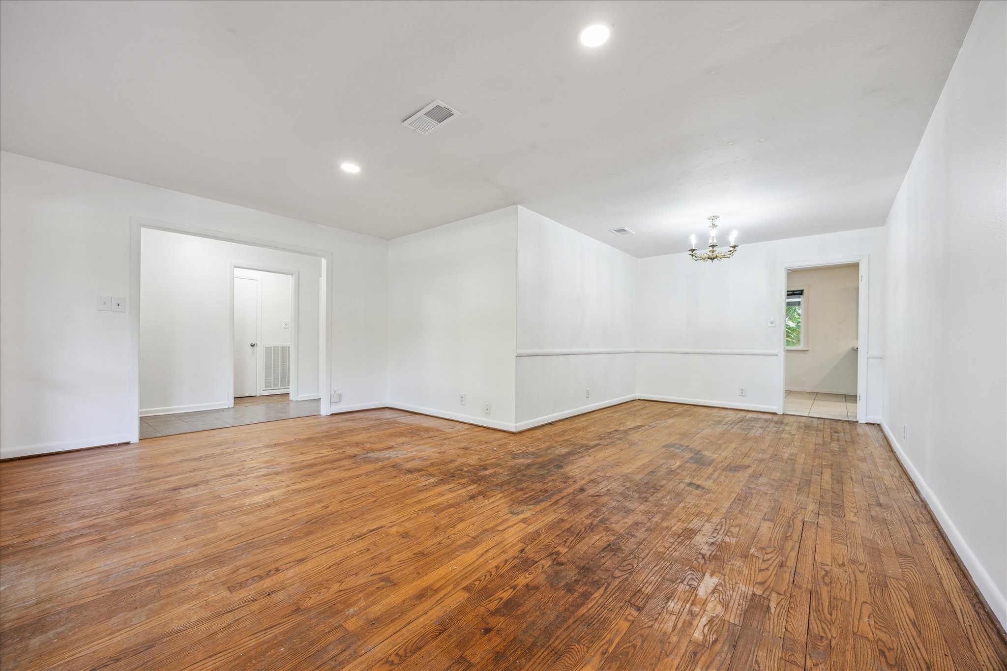 5419 Beechnut Street Houston, TX 77096 - Photo 6 of 28 Generous living and dining space with warm wood floors, modern lighting, and seamless flow into the kitchen for easy entertaining.