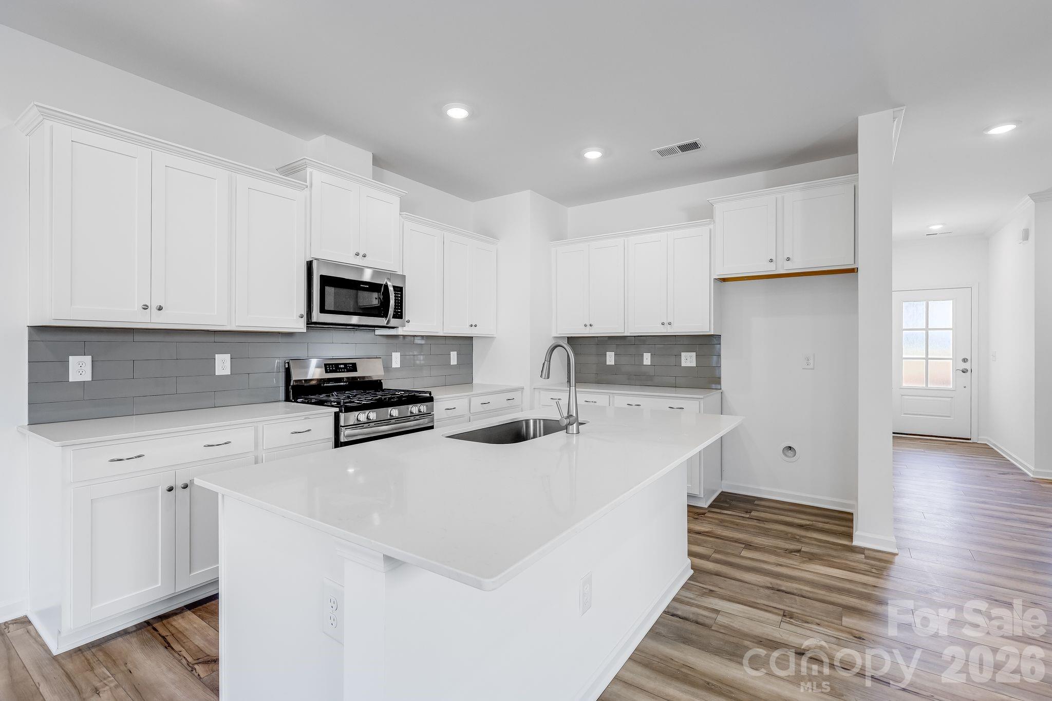 631 Sparano Loop York, SC 29745 - Photo 9 of 15 a kitchen with stainless steel appliances a sink a stove a refrigerator cabinets and a window