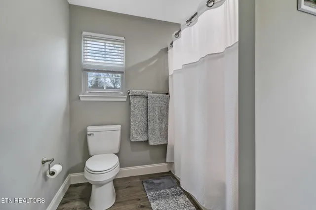a white toilet sitting next to a window