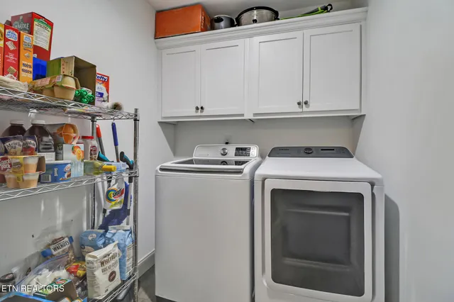 a utility room with fridge dryer and washer